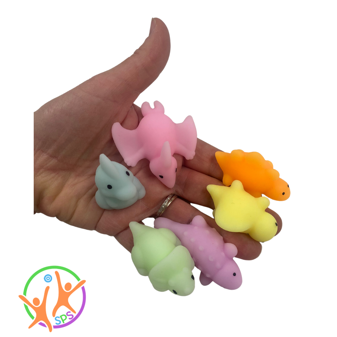 6 mochi dinosaurs placed on each finger and palm of an adult hand.