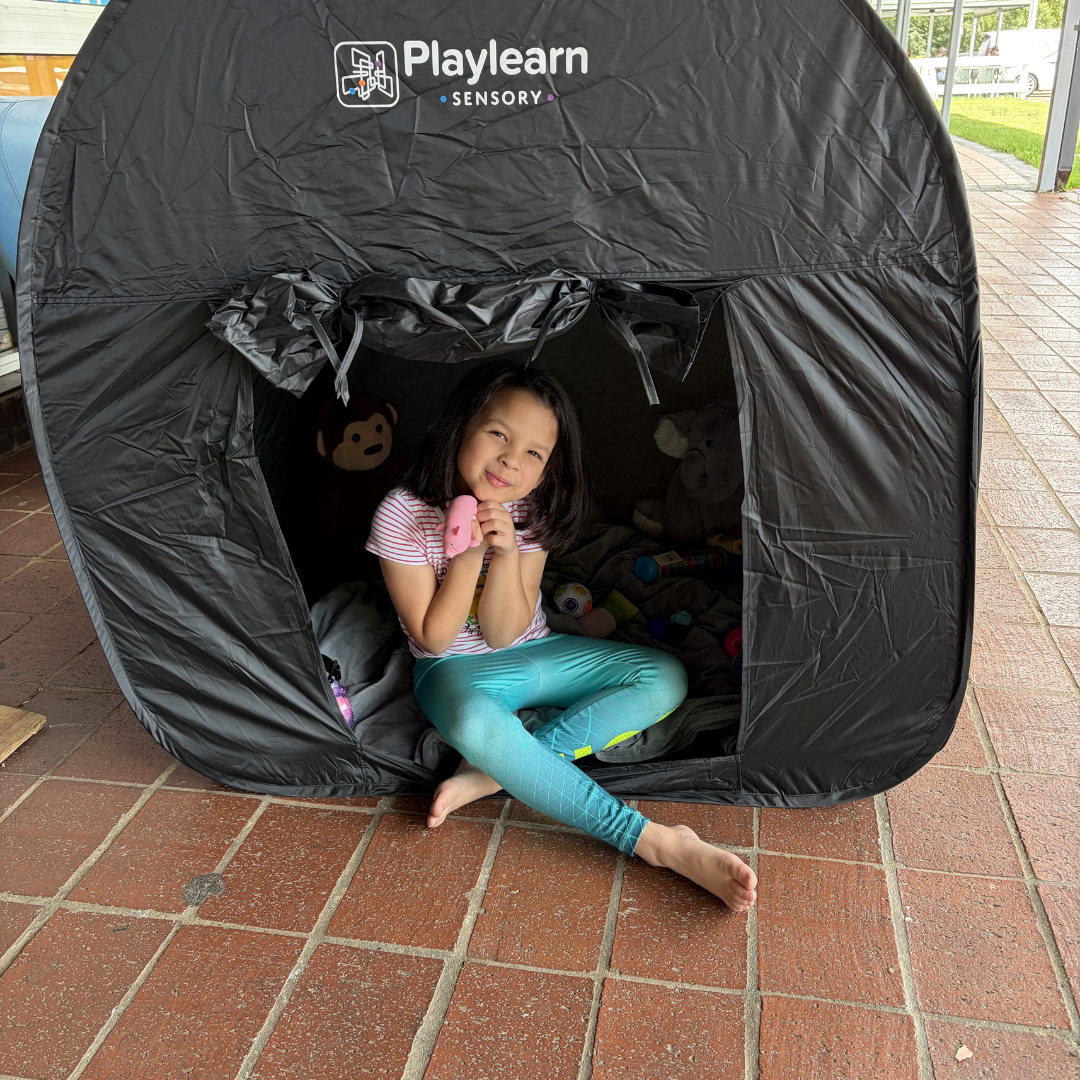 Child inside a Playlearn sensory tent on a tiled floor
