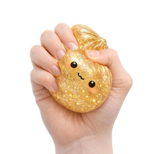 Hand squeezing a glittery gold mystery dumpling with a face