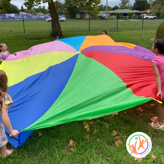 Kids using the rainbow parachute.