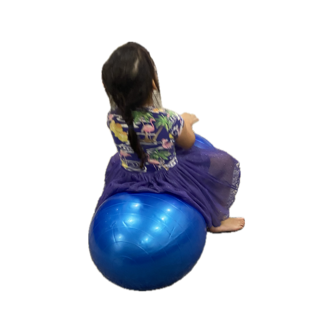 Back view of girl sitting on therapy peanut ball