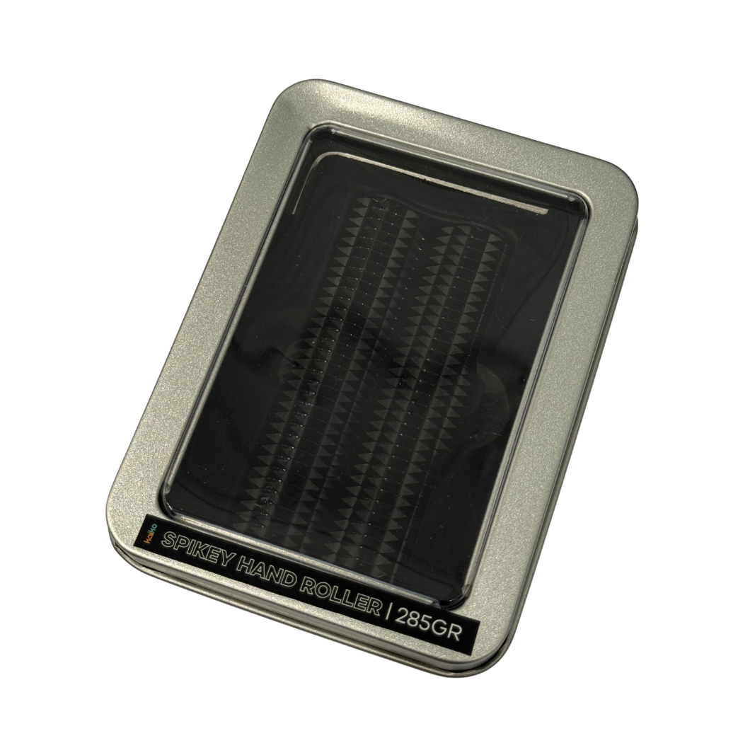 Black spikey hand roller against in a tin against a white background