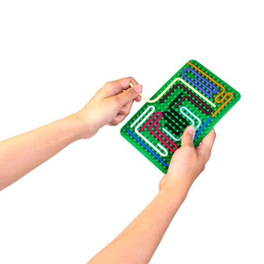 Hands holding the green sensory maze board with coloured strings weaved between the grid