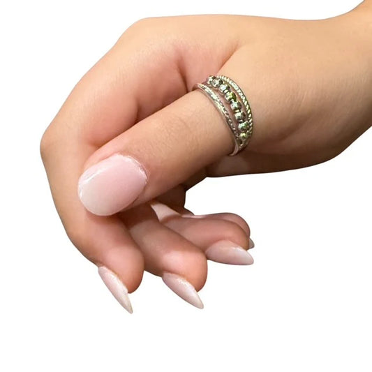 Hand with a silver Nyra fidget ring worn on the thimb