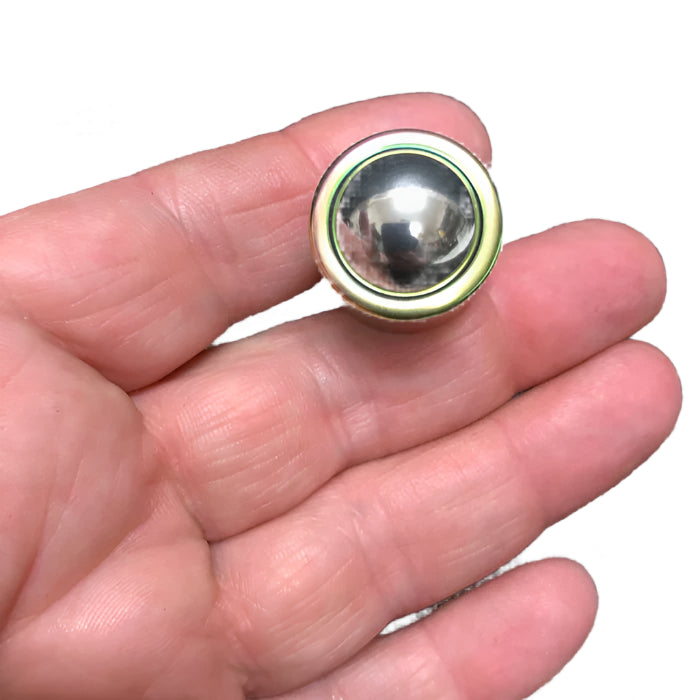 Metallic detonator fidget held between fingers.