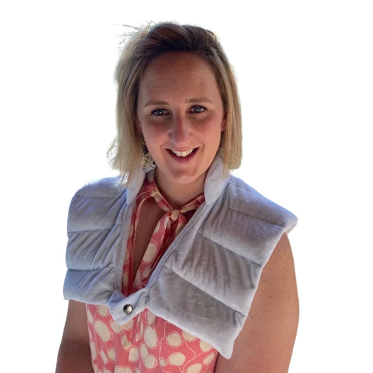 TheraZen heated weighted Neckcare wrap sitting around a ladies shoulders