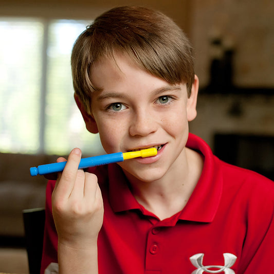Young boy brushing his teeth with a Yellow Brush TIp attached to the blue z Vibe handle