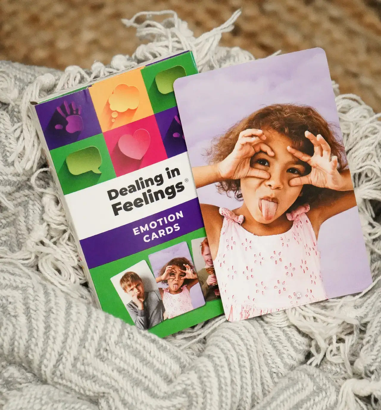 Dealing in feelings Emotion cards with a card of a girl making a silling face