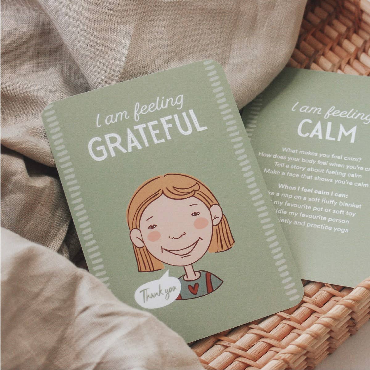 Card with illustration of a girl and text 'I am feeling grateful' on a woven surface.