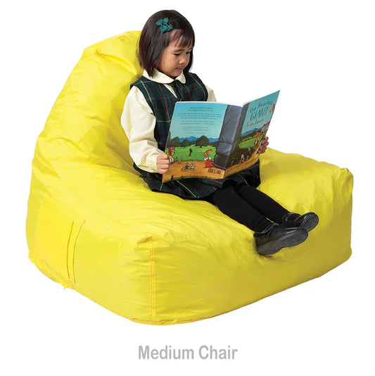 Child sitting on a yellow Elizabeth Richards Chill out chair reading a book against a white background