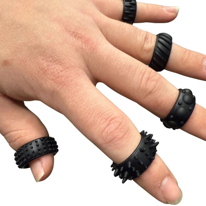 Hand wearing black textured Kaiko  Halo Picky Bands on each finger against a white background