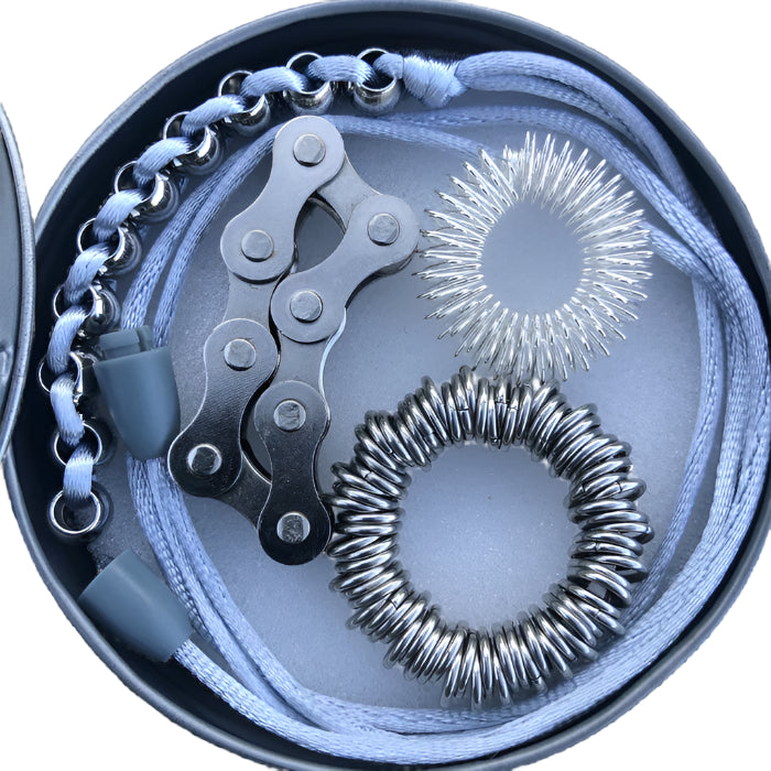 Close-up birds-eye view of Kiako fidgets,  bike chain, spikey, centipede and caterpillar necklace in tin