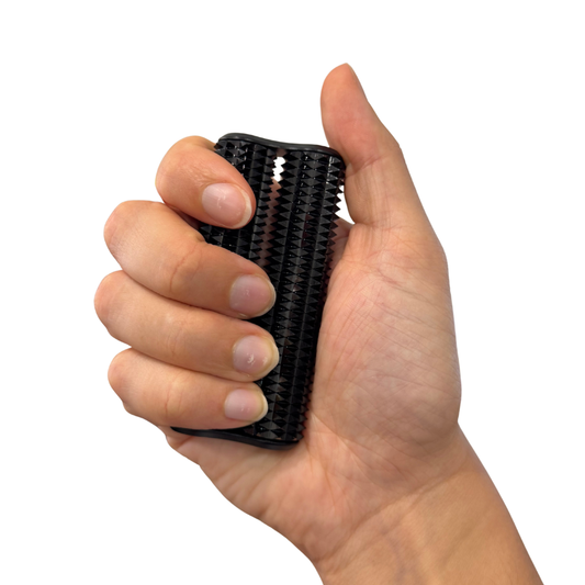 Hand holding a black spikey hand roller against a white background