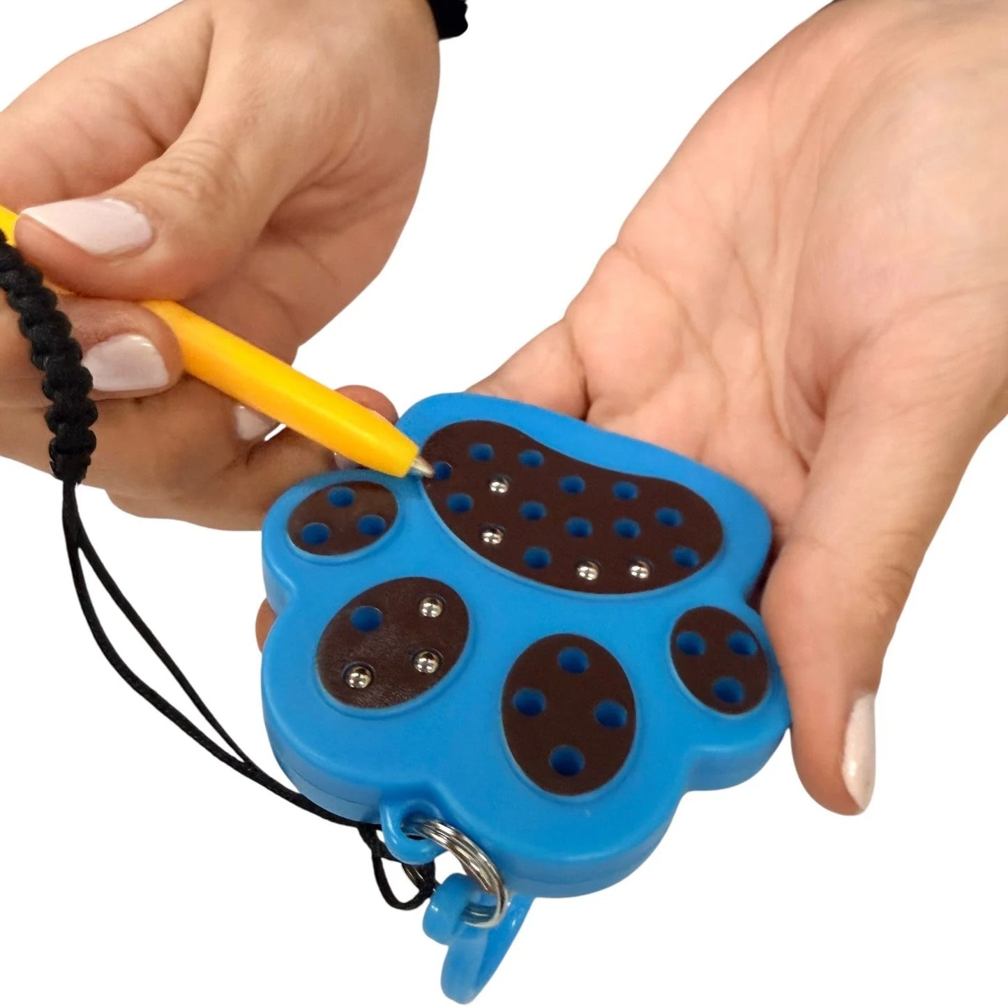 kaiko paw magnetic pad keyring being held by a hand on a white background