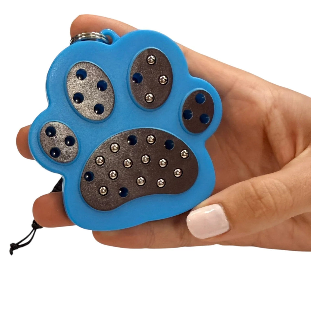 kaiko paw magnetic pad keyring being held by a hand on a white background
