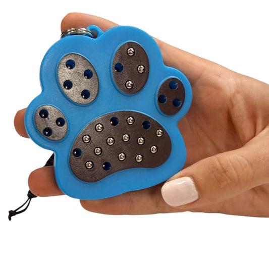 kaiko paw magnetic pad keyring being held by a hand on a white background