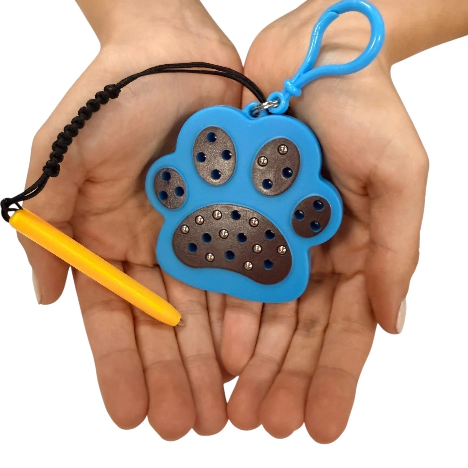 kaiko paw magnetic pad keyring being held by a hand on a white background