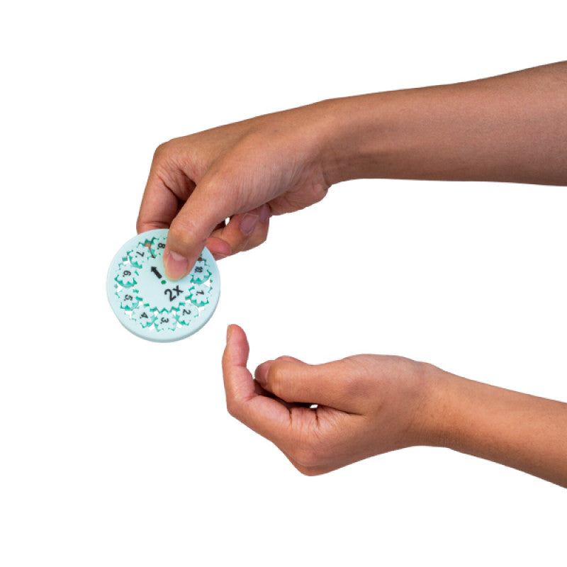 Hand holding a light blue multiplication fidget spinner with gears numbered 1-10 and a central "2x" multiplier.