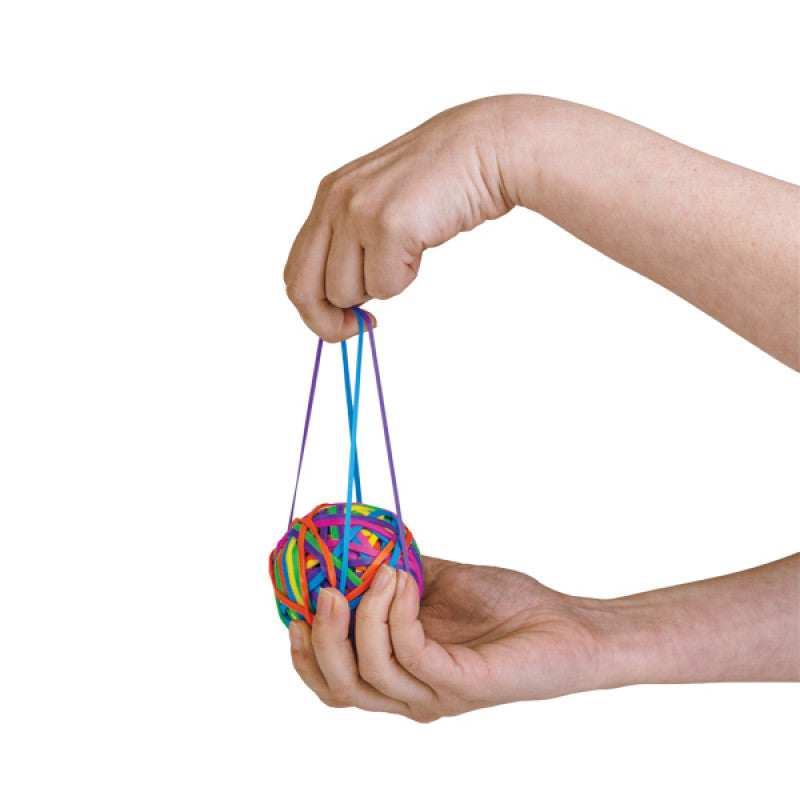 Close-up of a person holding a multi-colored rubber band ball. One hand gently supports the ball, while the other holds and stretches rubber bands.