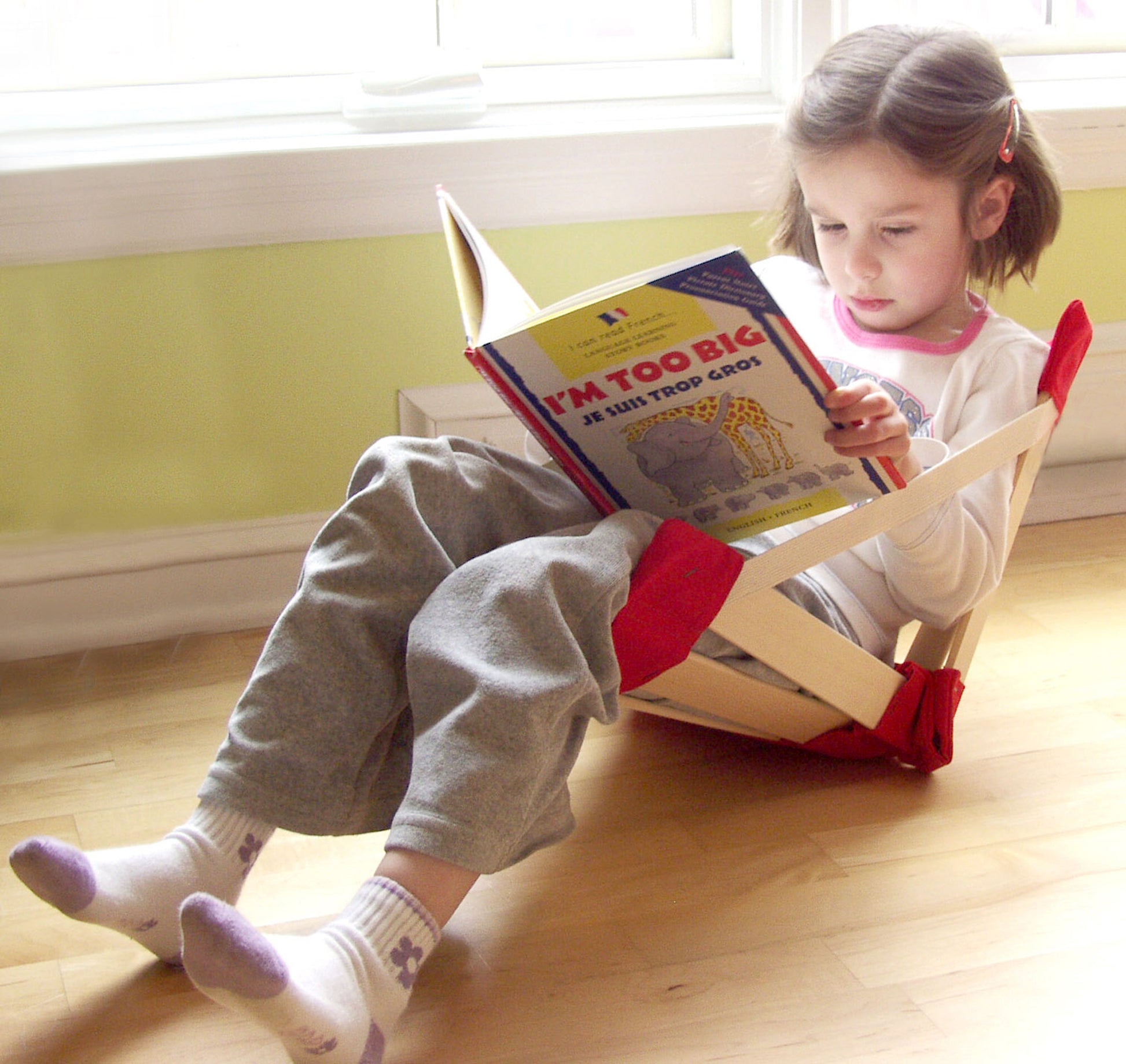 Child reading a book in a Petite HowdaHUG chair