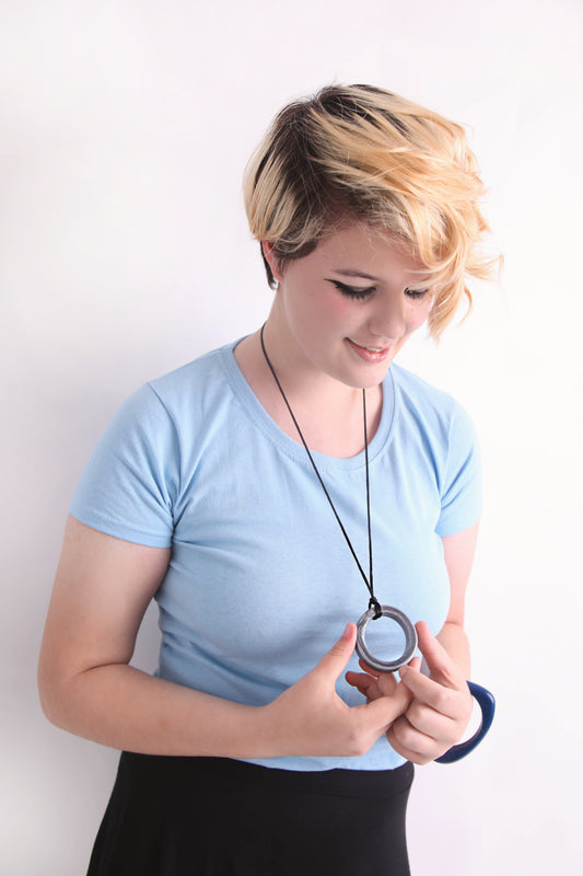 Woman holding a Silver realm ring pendant on her necklace