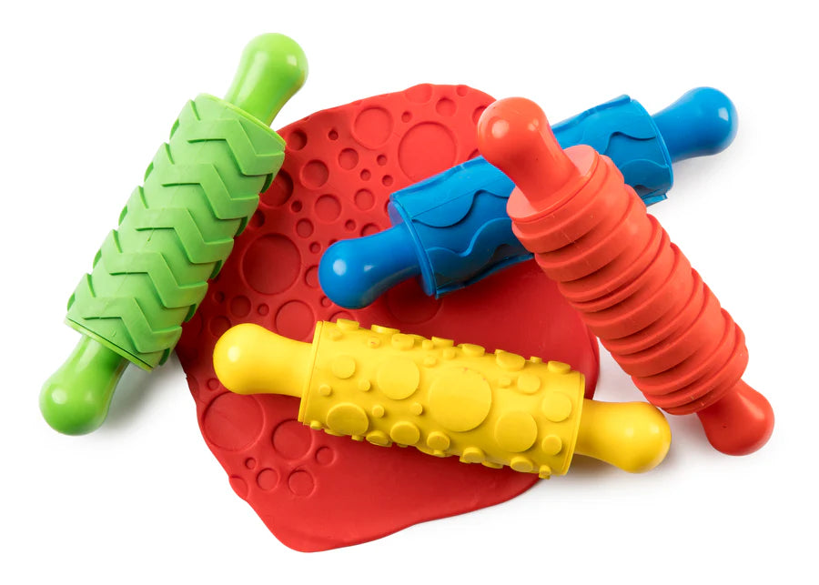 Colourful set of rolling pins with dough on a white background