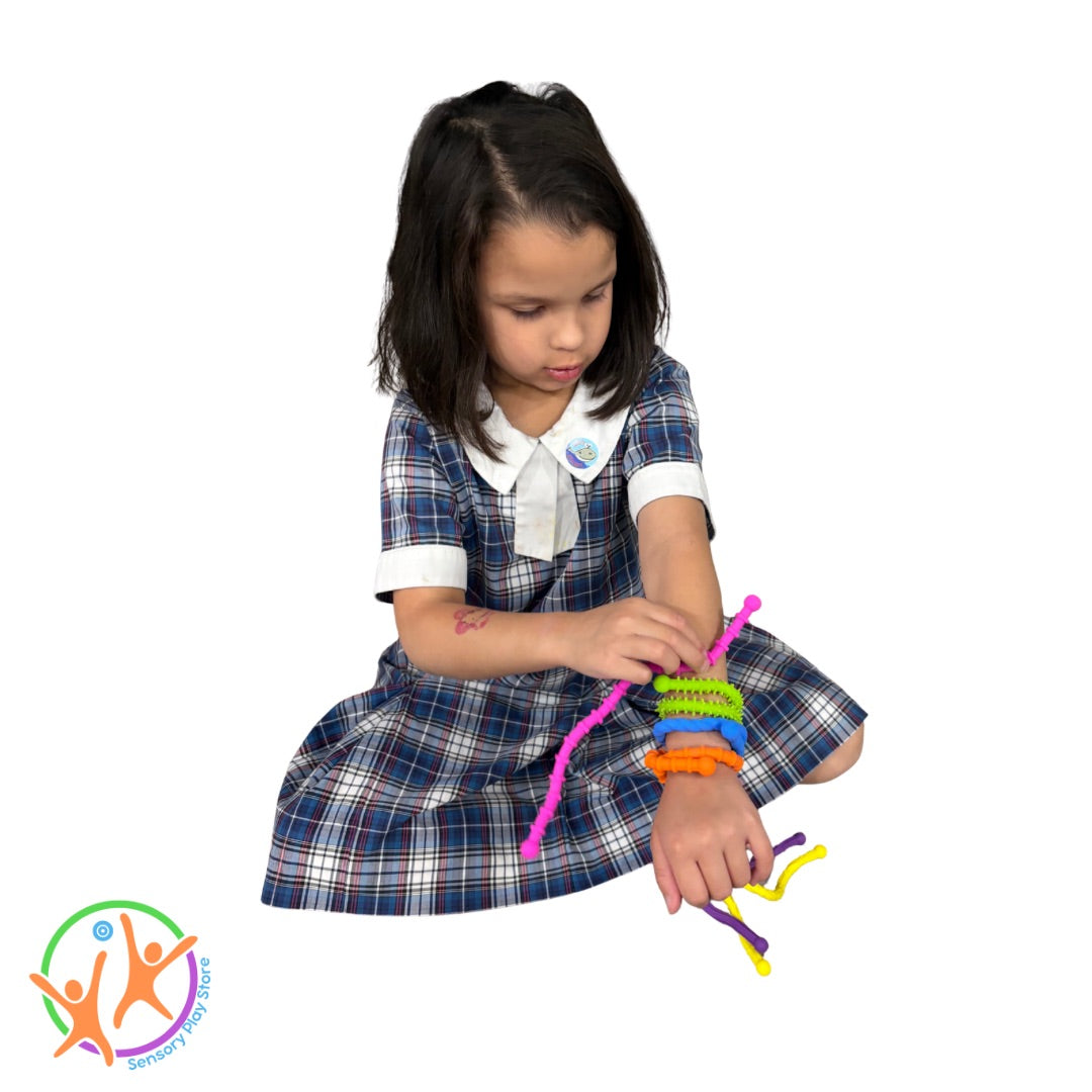 Young girl in a school uniform bending the textured twistable strings around her wrist like bangles