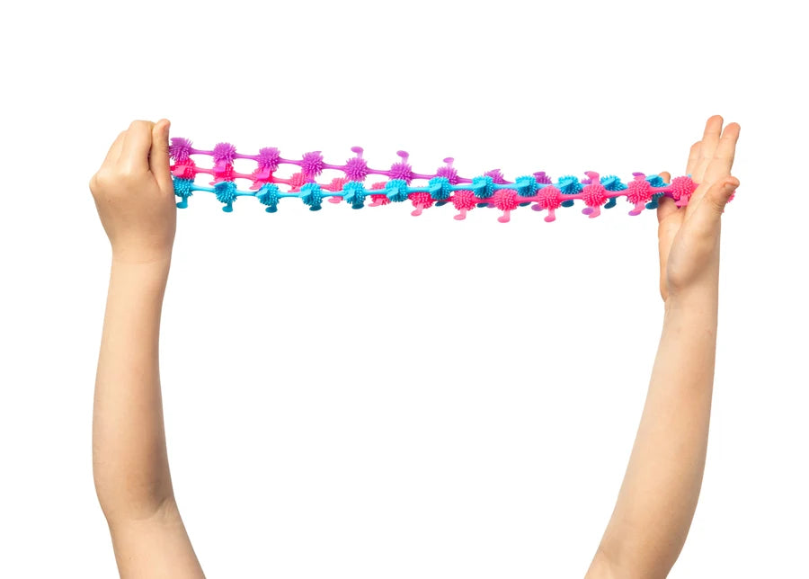 A pair of hands holding a stretched, textured caterpillars sensory sprout toys in pink and blue