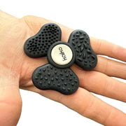 Black textured fidget spinner held in a hand