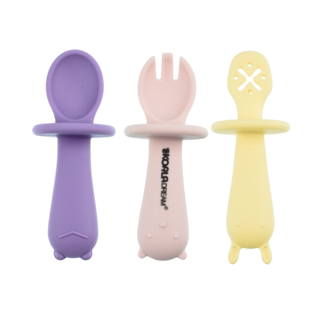 Three baby feeding utensils in purple, pink, and yellow on a white background