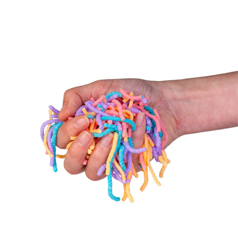 Hand holding colourful squirmy worms against a white background