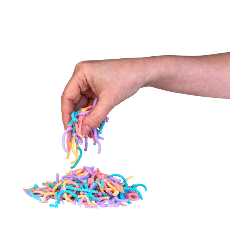 Hand holding squirmy worms above a pile of squiggly worm toys