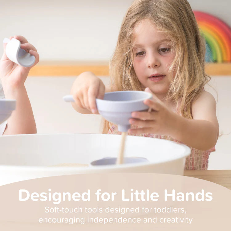 little girl playing with sand in a funnel