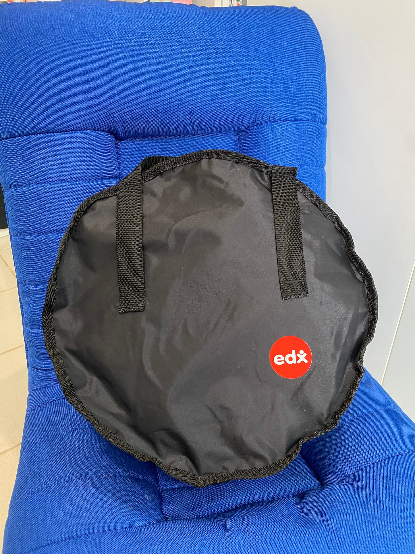 Black bag with 'edx' logo on a blue chair