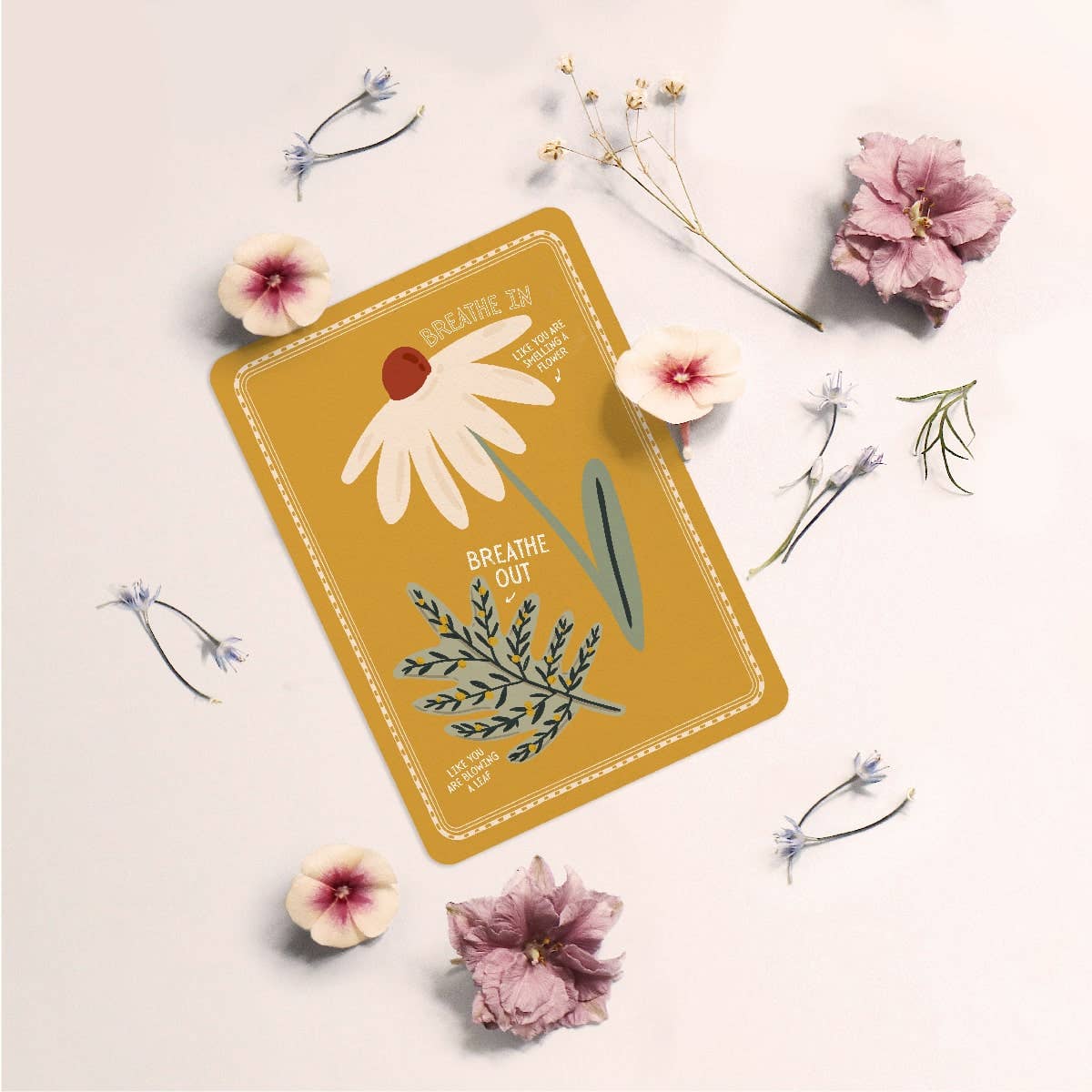 Card with floral design and text 'Breathe Out' surrounded by flowers on a light background