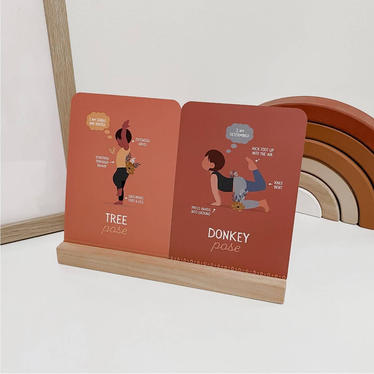 two mindful yoga Cards with illustrations of yoga poses on a wooden stand