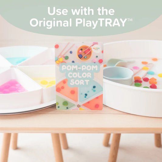 Pom-pom colour sort activity card with two sensory play trays in the background