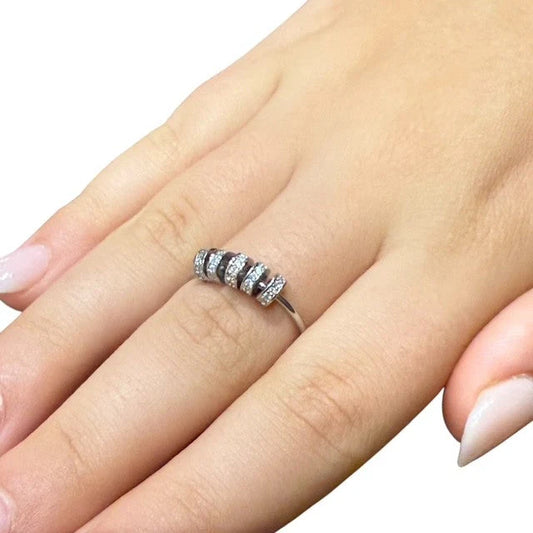 Silver Axia Fidget ring with 5 small diamante beads on a finger against a white background