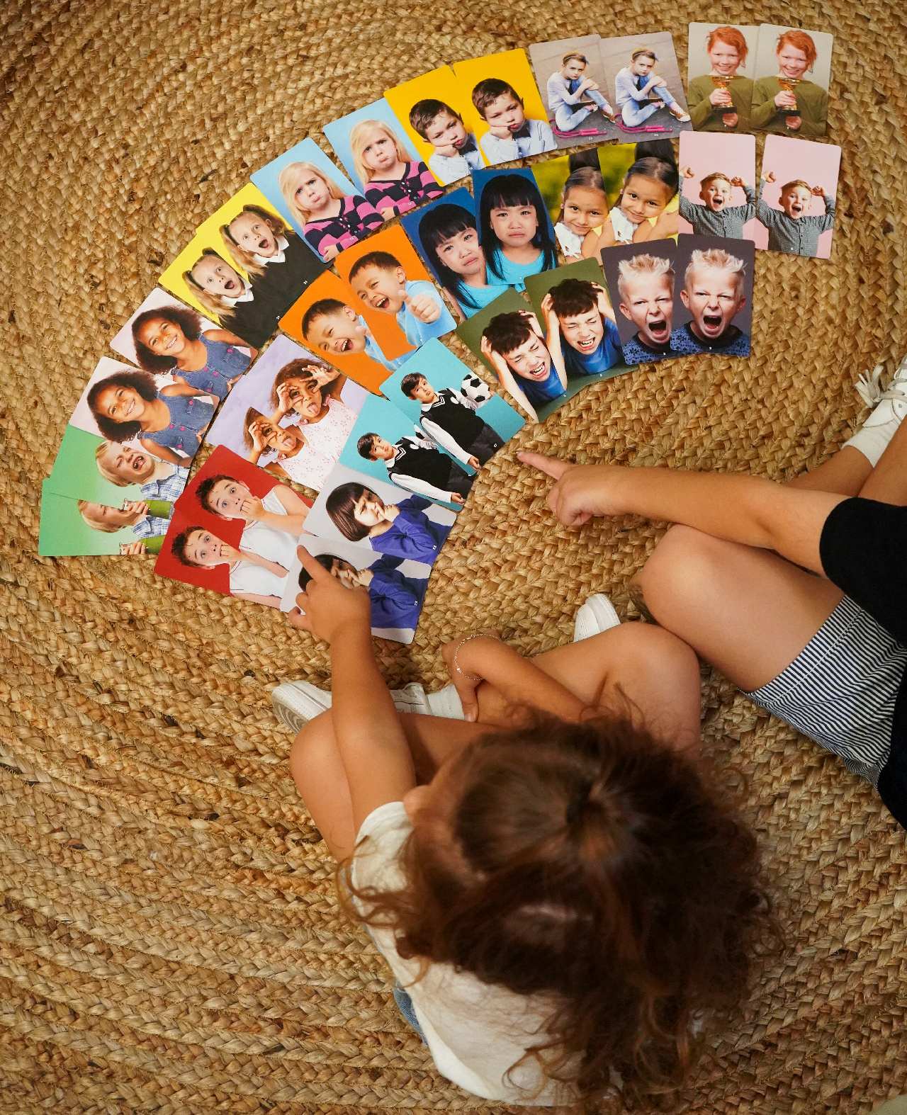 Children playing with a set of dealing with feelings and emotion cards matching pairs