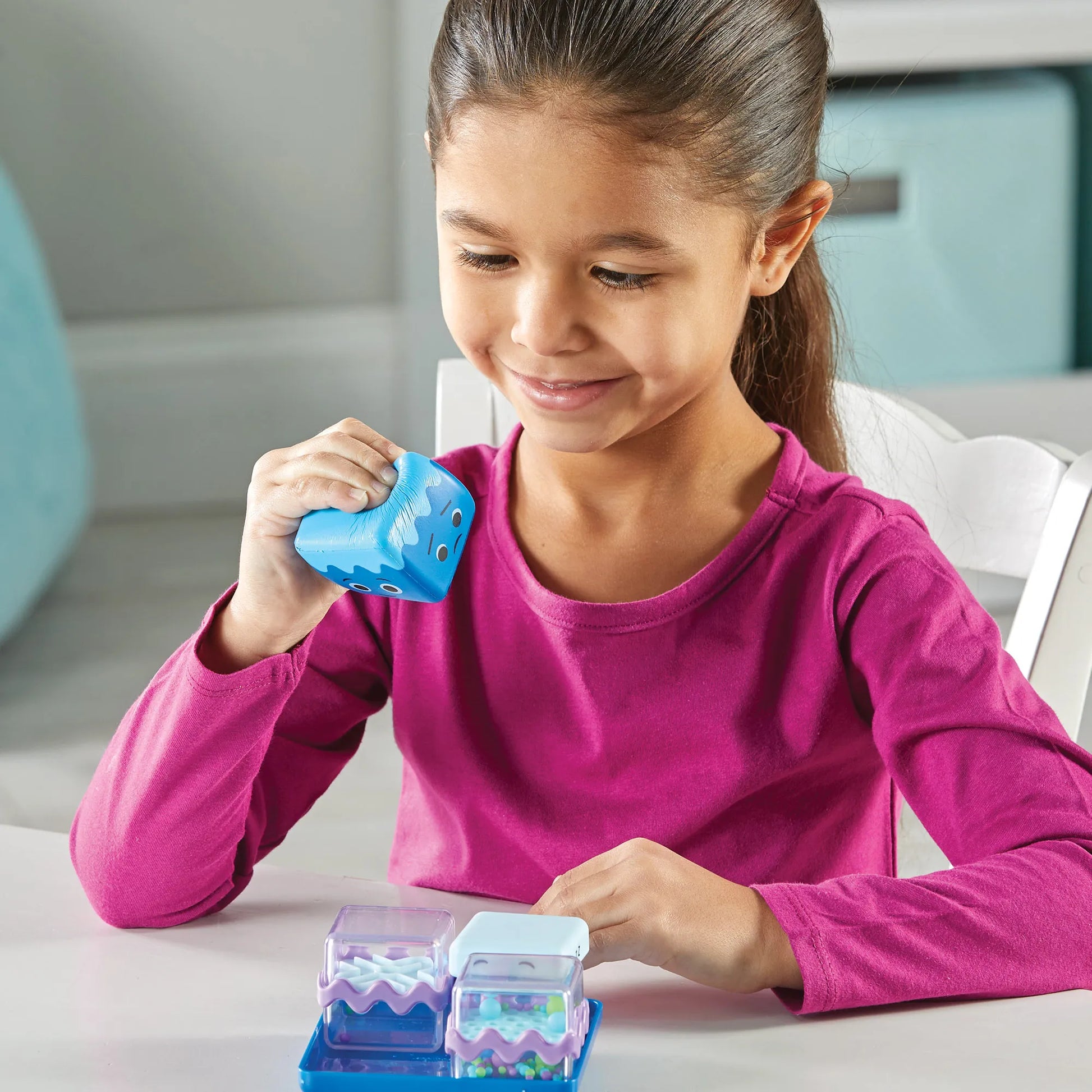 Young girl squeezing the foam squishy sensory fidget cube