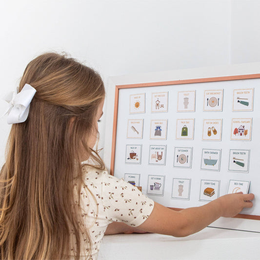 Child interacting with a framed magnetic visual schedule 