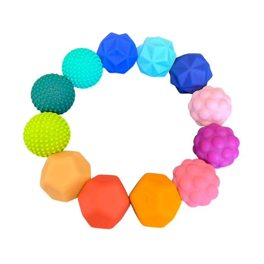 all of the 12 colourful speks odds silicone magnets  linked to form a ring or circle on  a white background