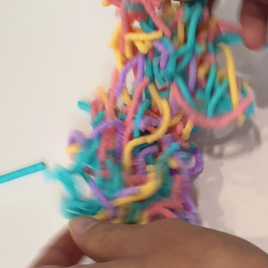 Video of a person hands playing with the squrimy womrs showing how they work