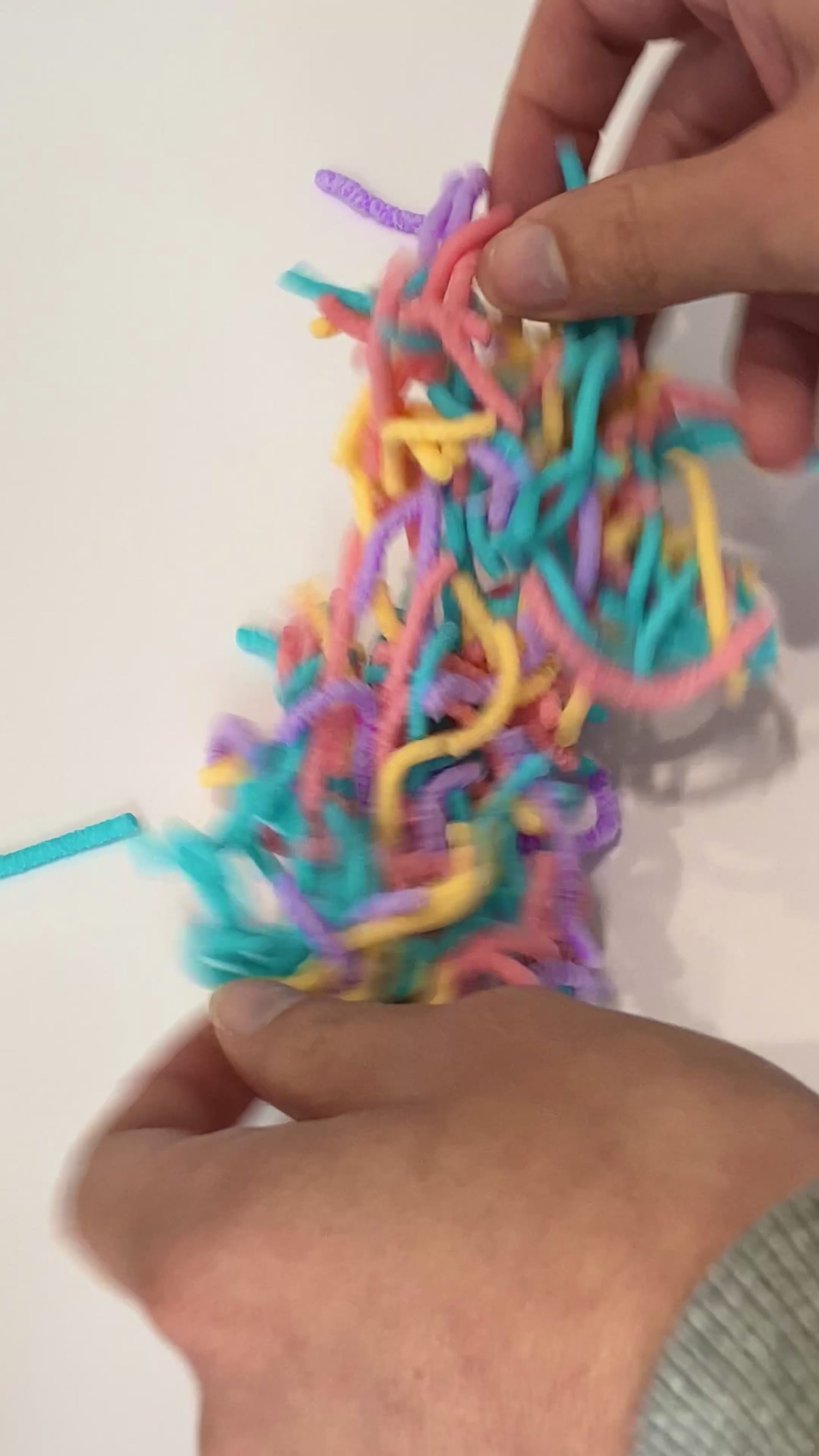Video of a person hands playing with the squrimy womrs showing how they work