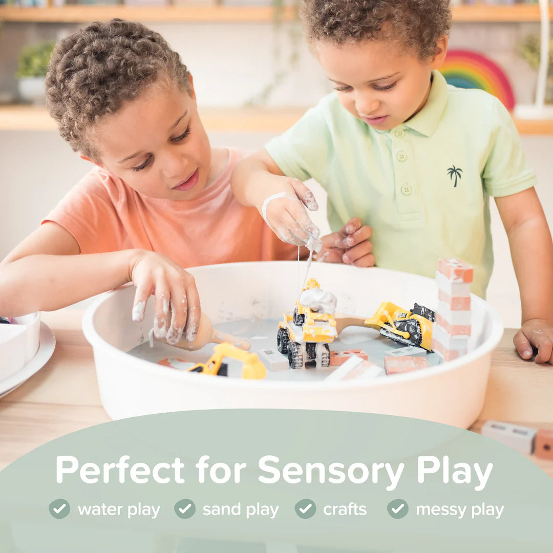 Two children playing with construction toys in a sensory tray.