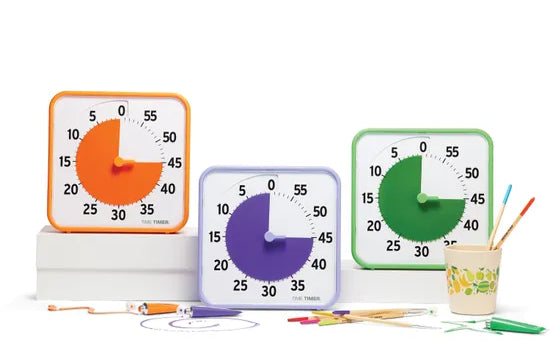 Time timer classroom set of  timers in secondary colours orange, purple and green. placed next to a cup.