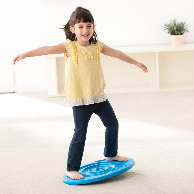 Child standing on a blue weplay maze balancing board 